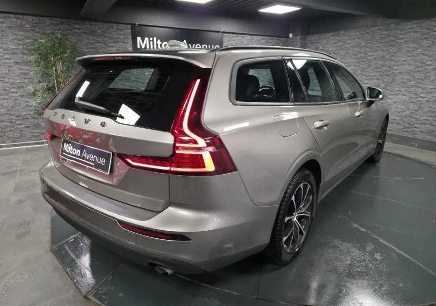 Vue 3/4 arrière droite d'un Volvo V60 gris métallisé avec feux arrière LED en forme de L et jantes alliage 17 pouces.