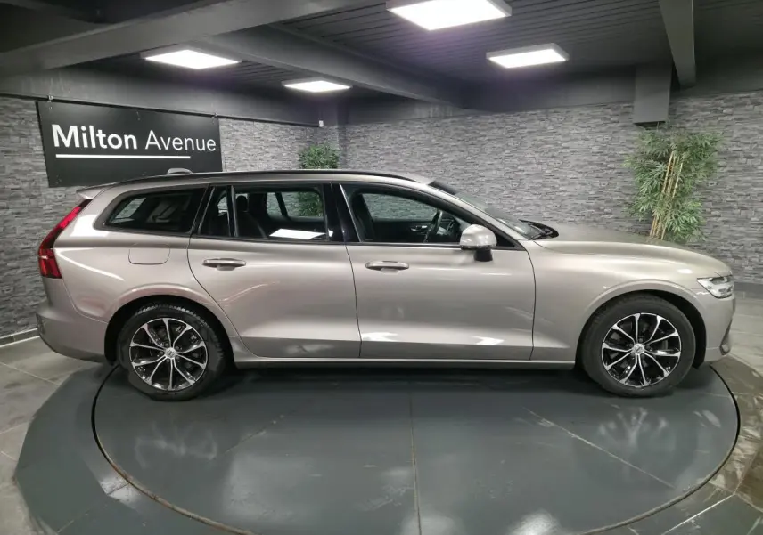 Volvo V60 gris métallisé vue de profil côté gauche, avec jantes alliage 17 pouces et toit noir.