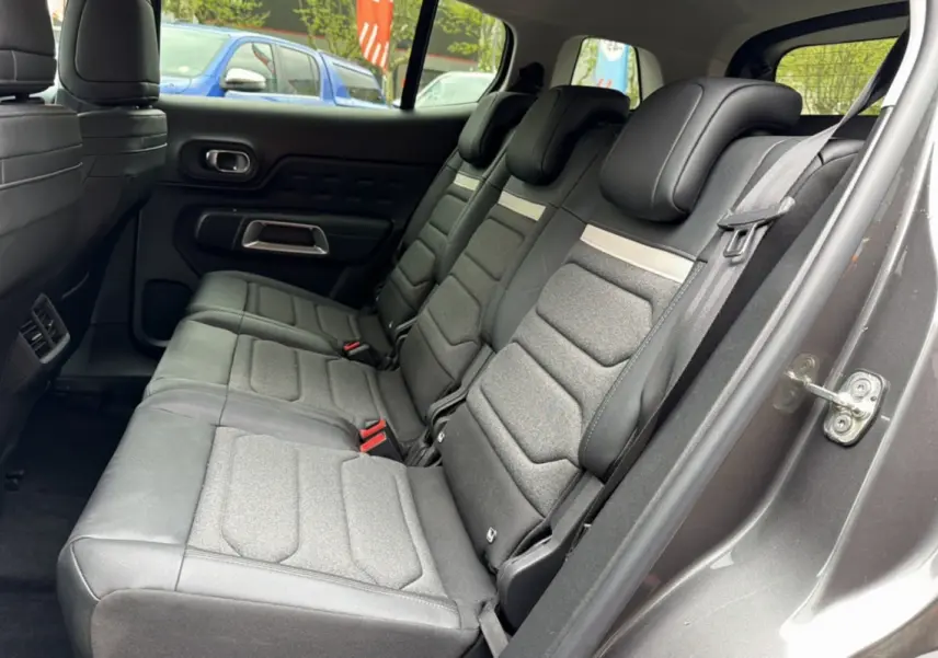 Vue intérieure côté droit des trois sièges arrière individuels en tissu gris du Citroën C5 Aircross Hybrid 2025.