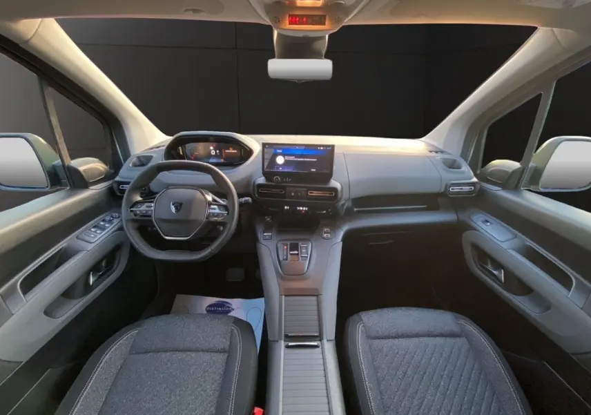 Vue intérieure avant du Peugeot Rifter gris clair 2026, avec tableau de bord moderne et écran tactile central.