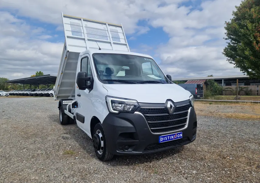 Renault Master Châssis cabine blanc en 3/4 avant droit avec benne relevée et roues jumelées visibles.