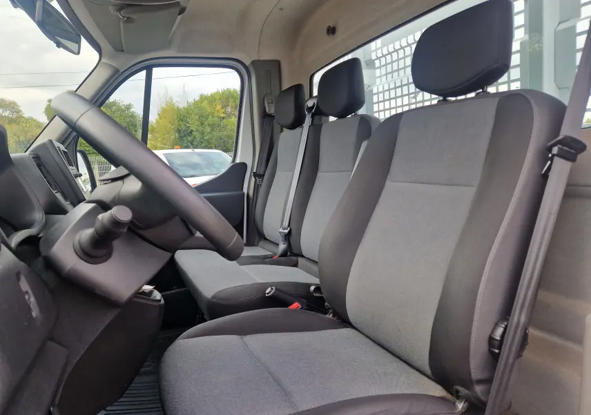 Vue intérieure côté conducteur du Renault Master Châssis Cabine blanc 2024, montrant les sièges tissu gris et noir.