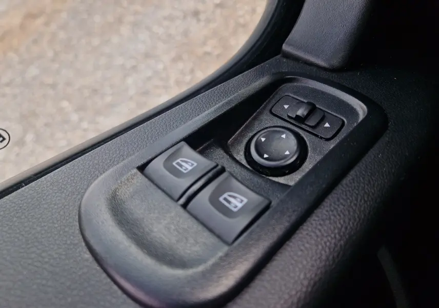 Gros plan sur les commandes de lève-vitres et réglage des rétroviseurs côté conducteur du Renault Master Châssis Cabine blanc.