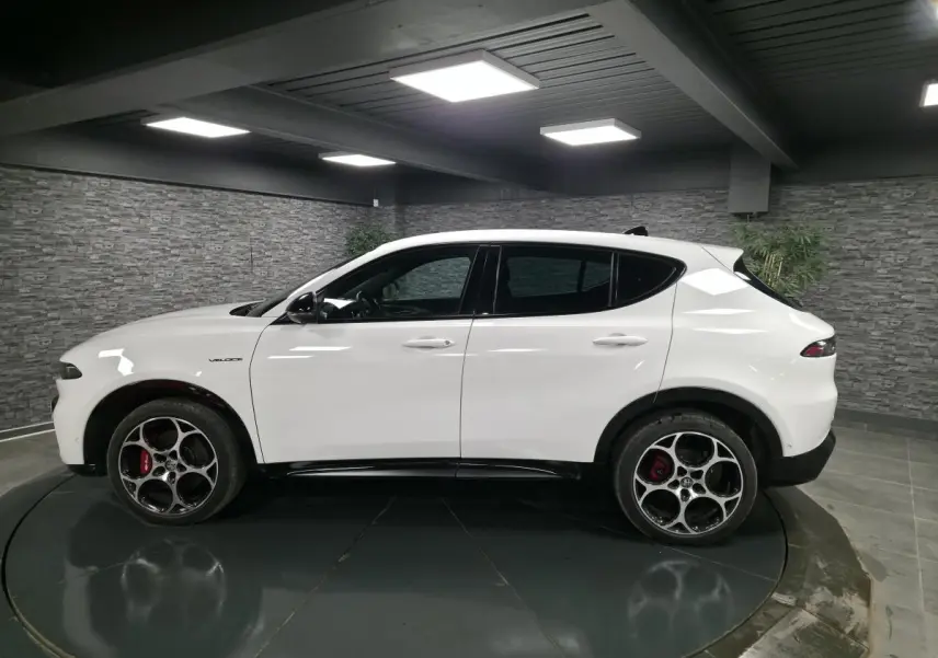 Vue de profil côté gauche d'un Alfa Romeo Tonale blanc avec jantes alliage 19 pouces et étriers de frein rouges.