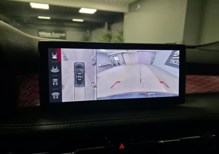 Écran intérieur affichant la caméra 360° de l'Alfa Romeo Tonale blanc, vue arrière en parking intérieur.