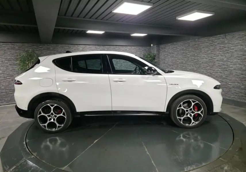 Vue de profil côté gauche d'une Alfa Romeo Tonale blanche avec jantes alliage 19 pouces et étriers de frein rouges.