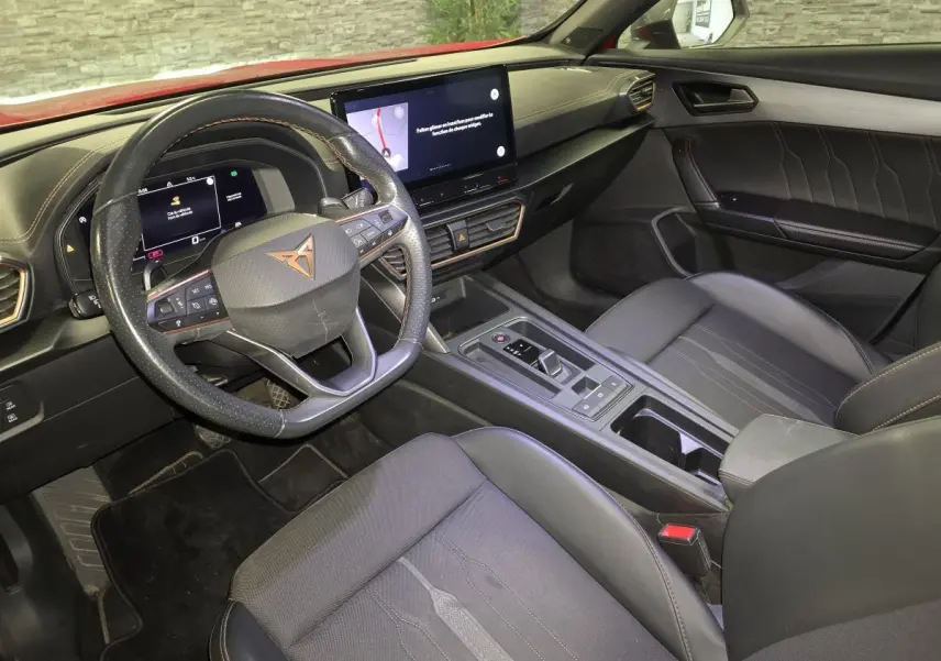 Intérieur de la CUPRA Formentor vu côté conducteur, avec volant sport, écran tactile et sellerie noire aux surpiqûres cuivre.