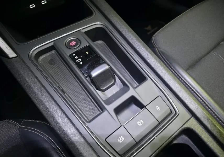 Vue rapprochée de la console centrale noire du CUPRA Formentor avec levier de vitesse automatique et bouton start/stop rouge.