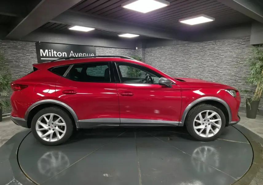 Profil droit d'un CUPRA Formentor rouge 2022 avec jantes alliage 18 pouces et détails noir alu contrastants.