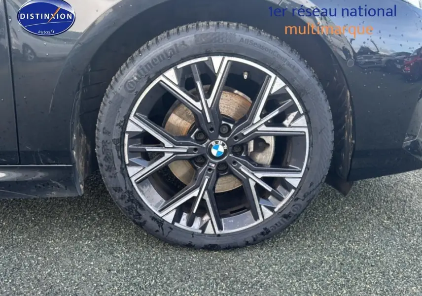 Gros plan sur la roue avant droite d'une BMW Série 1 noire avec jante alliage au design sportif M.