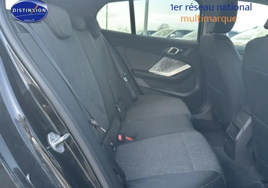 Vue intérieure côté gauche de la banquette arrière en tissu anthracite d'une BMW Série 1 noire 2024.