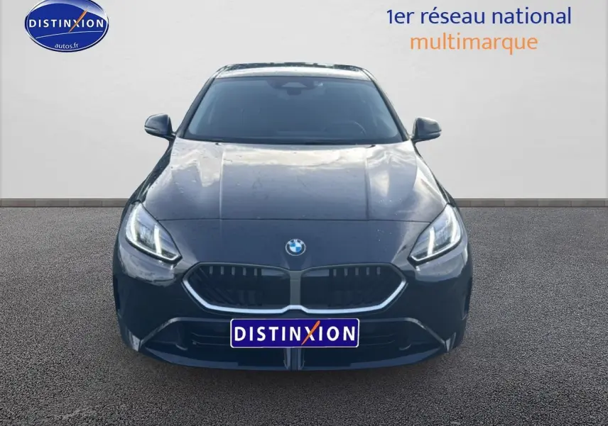 Vue avant d'une BMW Série 1 noire 2024 avec calandre double haricot et phares LED allumés.