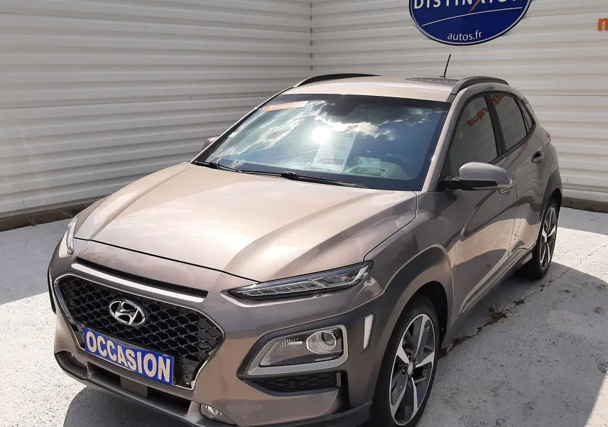 Vue 3/4 avant droite d'un Hyundai Kona gris métallisé 2018 avec calandre noire et jantes alliage bicolores.