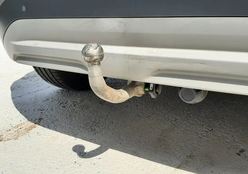 Gros plan sur l'attelage arrière usé d'un Hyundai Kona gris, visible sous le pare-chocs arrière.