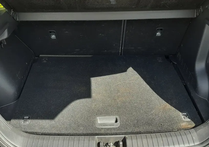 Vue plongeante sur le coffre ouvert d'une Hyundai Kona gris 2018, montrant un espace de rangement propre et vide.