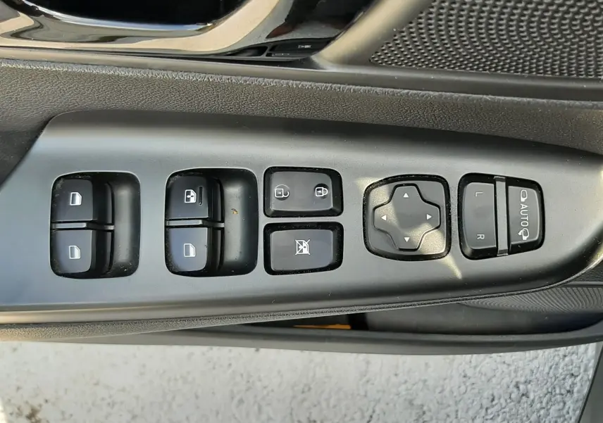 Gros plan sur les commandes de lève-vitres et rétroviseurs côté conducteur d'une Hyundai Kona gris 2018.