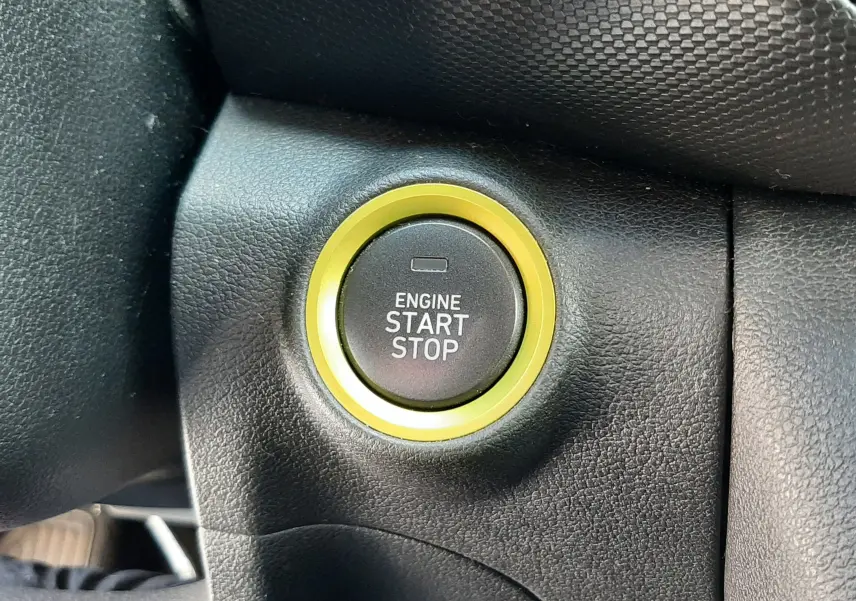 Gros plan sur le bouton start/stop entouré d'un anneau jaune dans l'habitacle noir du Hyundai Kona gris 2018.