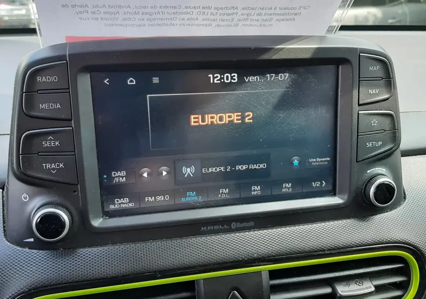 Vue rapprochée de l’écran multimédia tactile du tableau de bord du Hyundai Kona gris, avec radio Europe 2 affichée.