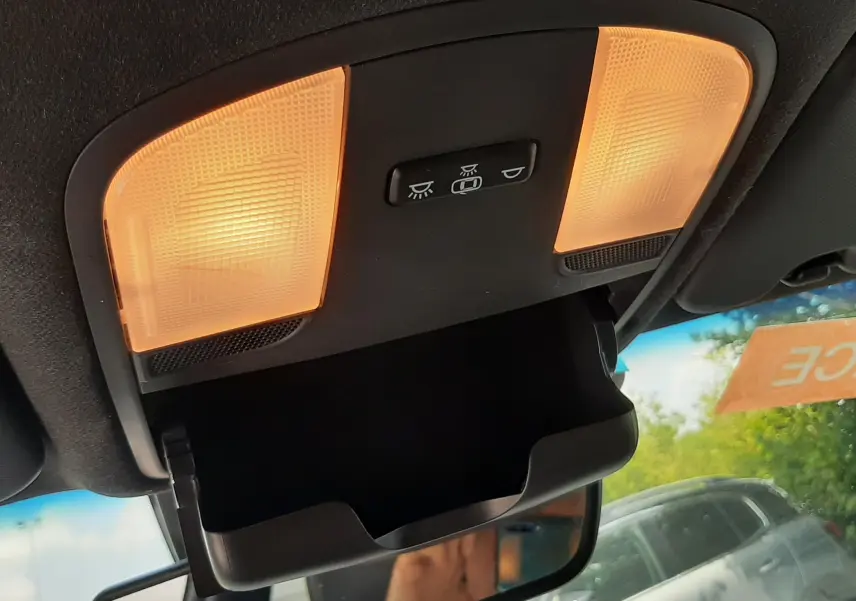 Plafonnier intérieur allumé avec rangement lunettes ouvert, vue vers l'avant du Hyundai Kona gris de 2018.