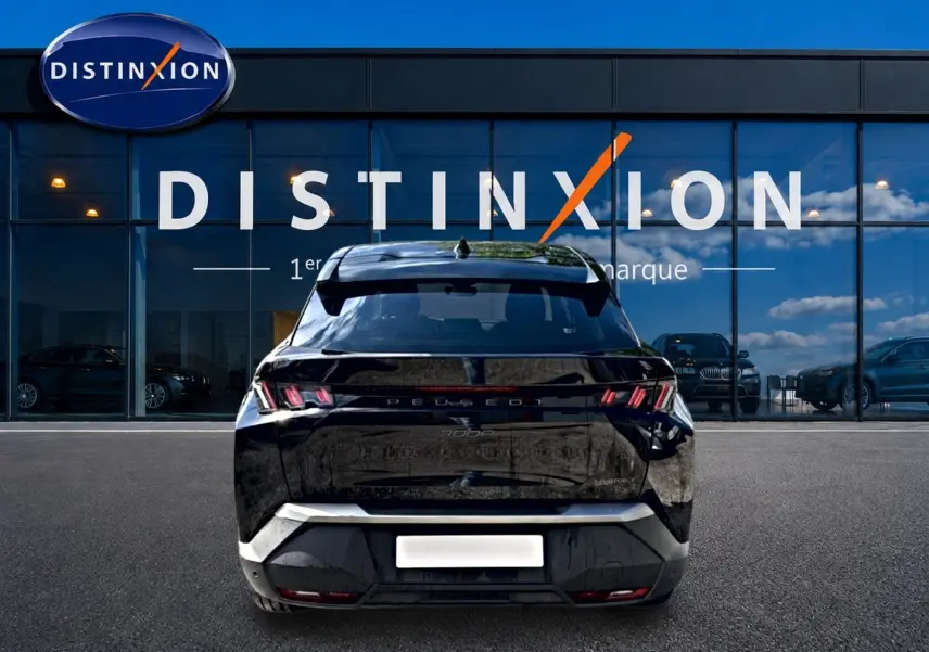 Vue arrière du Peugeot 3008 noir 2025 avec feux LED caractéristiques et becquet arrière, devant une vitrine Distinxion.