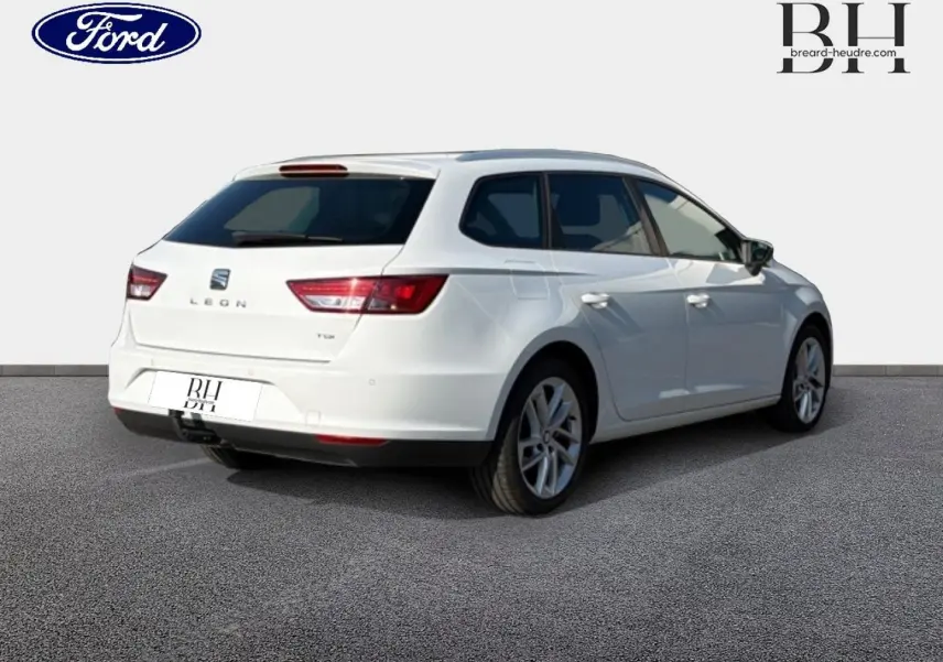 Vue 3/4 arrière droite d'une SEAT Leon ST gris étoile, break compact avec feux arrière LED et barres de toit.