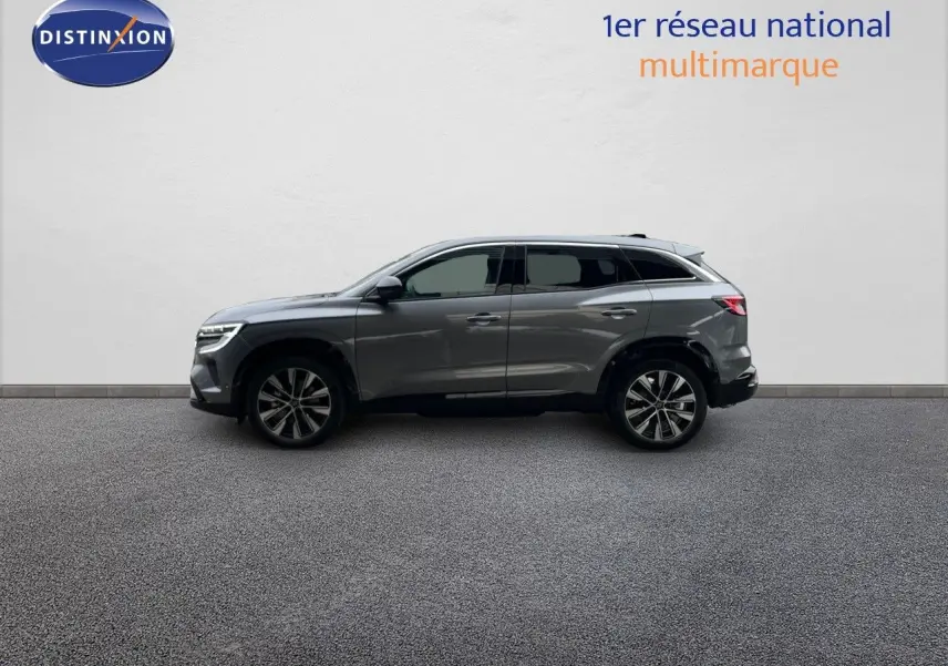 Profil latéral droit d'un Renault Austral gris schiste métallisé 2025, SUV hybride avec jantes bi-ton et vitres teintées.