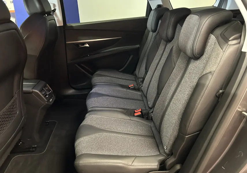 Vue latérale droite des sièges arrière en tissu et cuir du Peugeot 5008 gris, mettant en valeur les appuie-têtes et la finition intérieure.