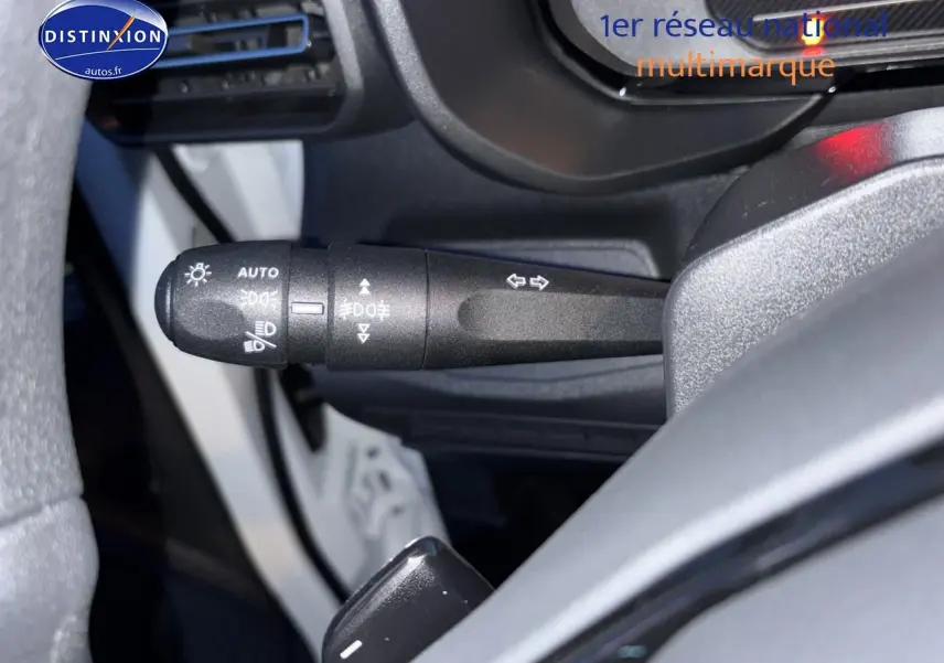 Gros plan sur la commande des phares et clignotants côté gauche du volant d’un Citroën Berlingo Fourgon blanc.