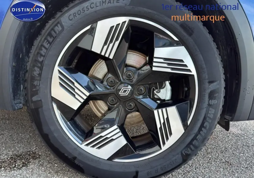 Gros plan sur la roue avant droite du Renault Symbioz bleu iron metal avec jante noire et argentée au design moderne.