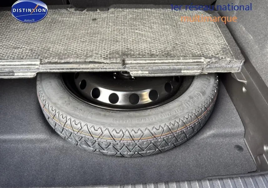 Gros plan sur la roue de secours temporaire sous le plancher du coffre du Renault Symbioz bleu iron metal.