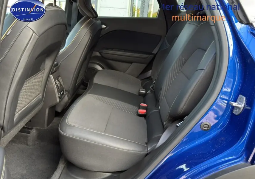 Vue côté droit sur l'intérieur arrière du Renault Symbioz bleu iron metal, sièges tissu et cuir noir avec surpiqûres claires.