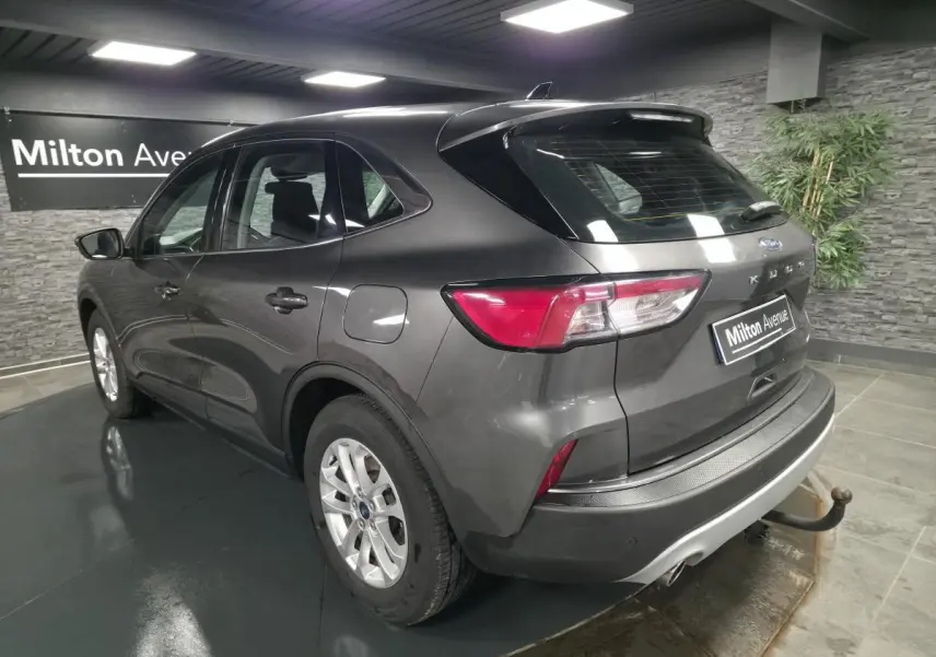 Vue 3/4 arrière droite du Ford Kuga gris métallisé 2020 avec attelage fixe et jantes alliage 17 pouces.