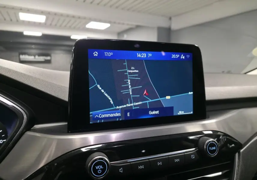 Écran tactile central du Ford Kuga 2020 affichant la navigation, avec console en finition métal brossé et boutons noirs.