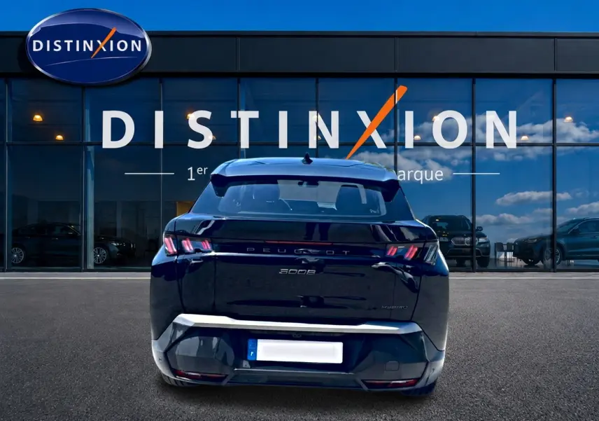 Vue arrière d'un Peugeot 3008 noir 2025 avec feux LED caractéristiques et becquet arrière visible devant une vitrine Distinxion.