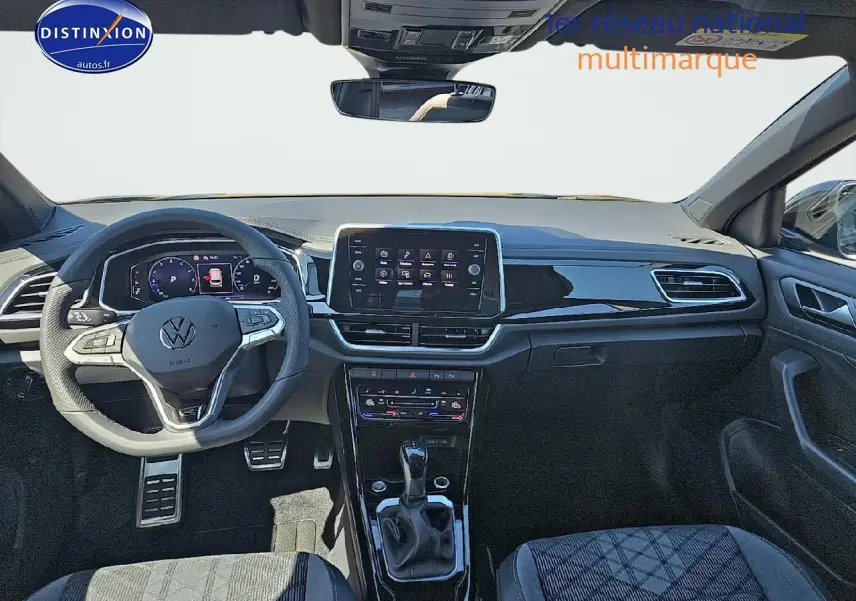 Vue avant de l'intérieur du Volkswagen T-Roc noir perle, avec volant cuir multifonction et écran tactile central.