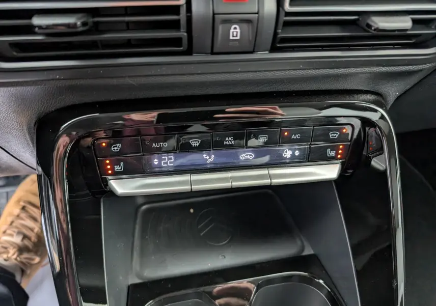 Panneau de commande de climatisation et recharge sans fil dans l'habitacle du Citroën C3 Aircross 2025.