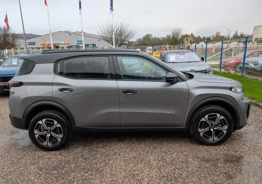 Vue de profil côté gauche d'un Citroën C3 Aircross gris métallisé avec toit noir et jantes alliage 17 pouces.