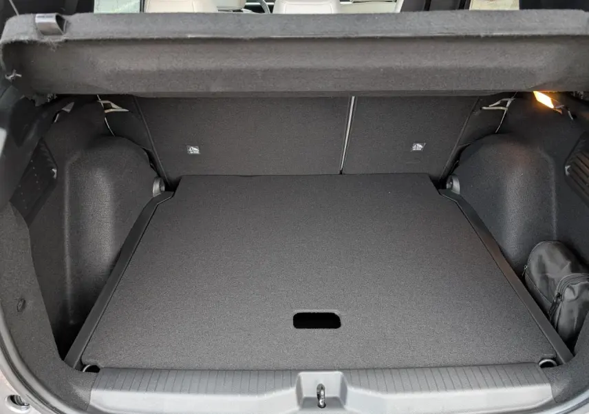 Coffre ouvert vu de l'arrière du Citroën C3 Aircross gris métallisé avec plancher de coffre plat et rangement noir.