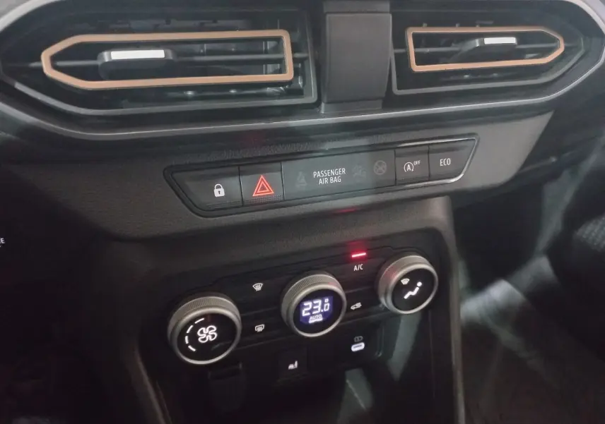 Détail de la console centrale noire de la Dacia Sandero Extreme+ 2024 avec commandes climatisation et boutons fonctionnels.