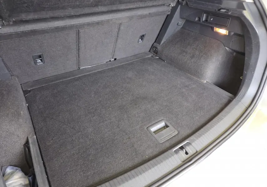 Coffre spacieux du Volkswagen Tiguan gris, vu de dessus avec plancher modulable et éclairage intérieur allumé.