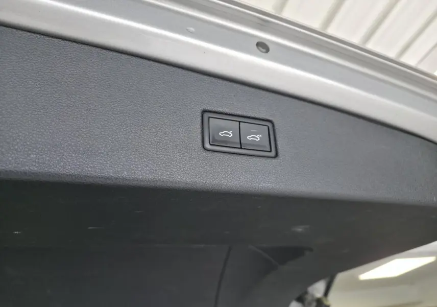 Gros plan sur les boutons de fermeture électrique du coffre du Volkswagen Tiguan gris, vue intérieure du hayon.