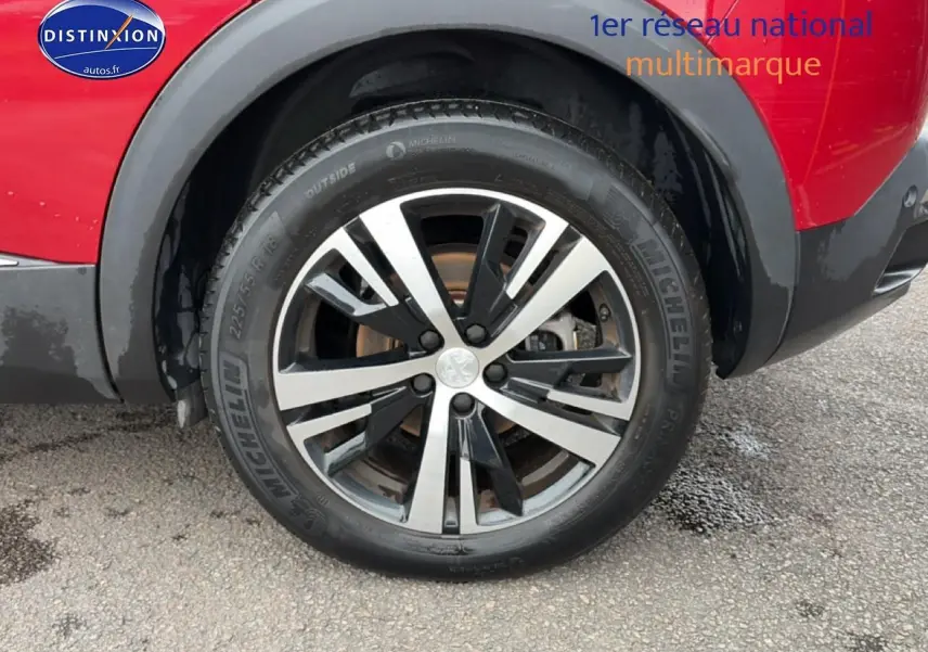 Gros plan sur la roue avant droite avec jante alu bicolore du Peugeot 3008 rouge 2022.