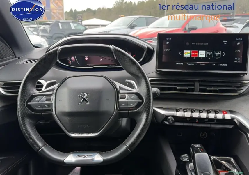 Vue intérieure centrée sur le volant cuir multifonction et l'écran tactile du Peugeot 3008 GT rouge 2022.