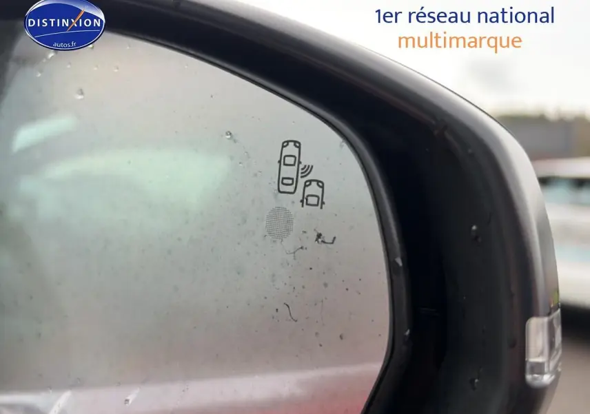 Gros plan sur le rétroviseur extérieur droit noir du Peugeot 3008 rouge, avec icône d'alerte angle mort visible.