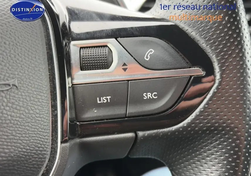 Gros plan sur les commandes audio au volant cuir perforé du Peugeot 3008 rouge 2022, version GT.