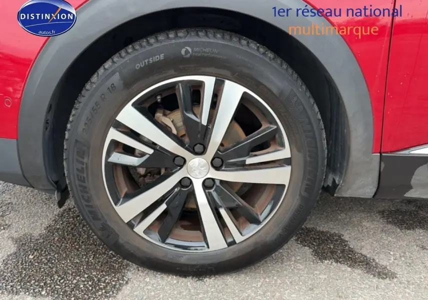 Gros plan sur la roue avant droite avec jante alu bicolore du Peugeot 3008 rouge 2022.
