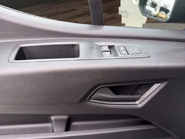 Vue rapprochée de la porte côté conducteur du Renault Master gris foncé, avec commandes électriques des vitres et rétroviseurs.