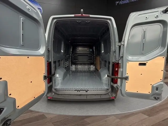 Vue arrière du Renault Master gris foncé 2025, portes ouvertes montrant l’espace de chargement vide et protégé.
