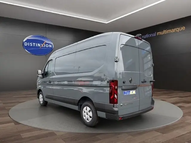 Vue 3/4 arrière droite d’un Renault Master gris foncé avec feux arrière LED et logo distinctif sur porte arrière.