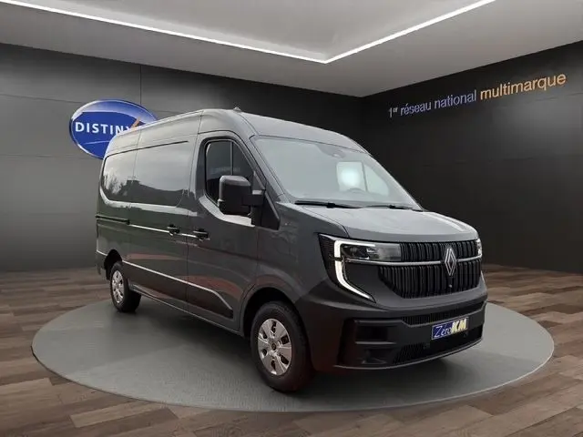Renault Master gris foncé vu en 3/4 avant droit, avec calandre noire distinctive et phares LED allumés.